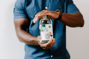 fit man holding bottle of organic mct oil